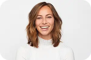 Smiling woman with perfect teeth in a white turtelneck sweater.