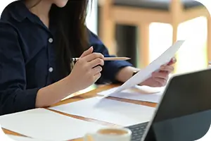 Woman sitting at her desk looking over a dental bill.