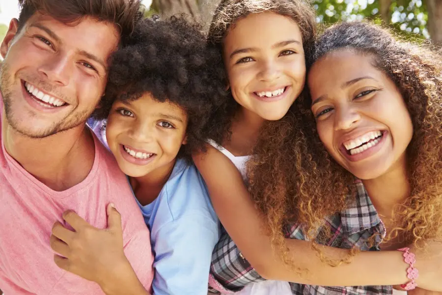 Happy family posing for a picture in the park.