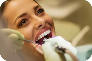 Middle aged woman in dentist chair getting her teeth cleaned.