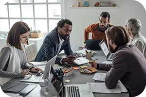 Group of people in an office reviewing plan paperwork.