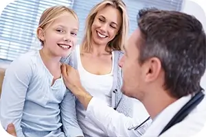 Dentist congratulating a mother and daughter on a great checkup.