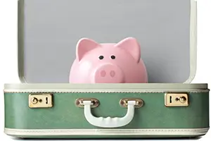 Piggy bank in a suitcase, ready for travel.